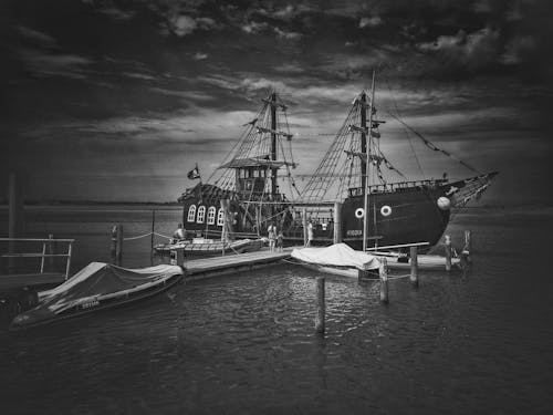Monochrome Photo of a Pirate Ship Docked at a Harbor