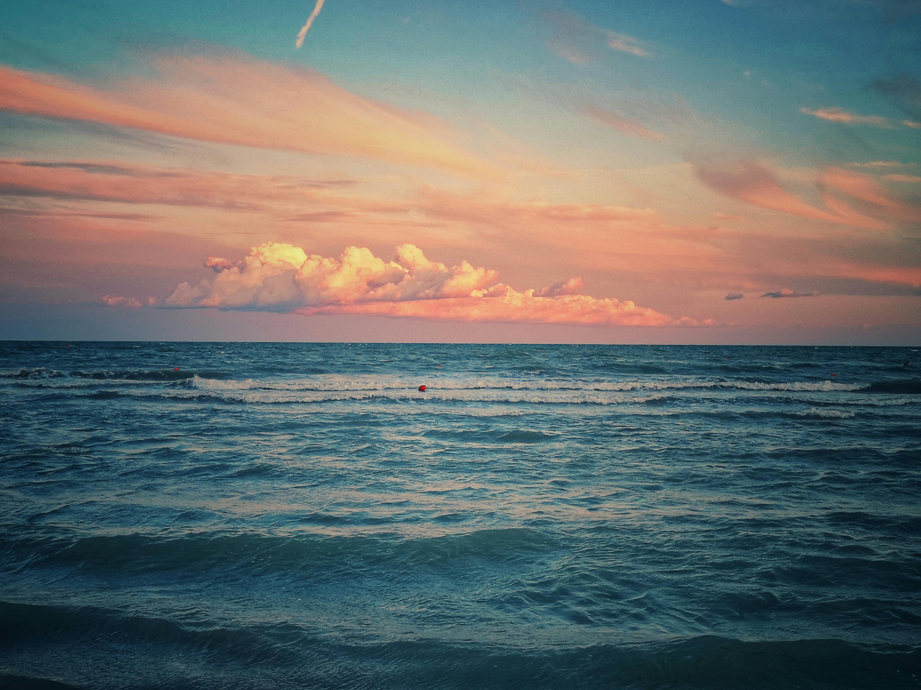 比比翁海洋上，宁静日落的迷人景色，五彩缤纷的云和温柔的波浪