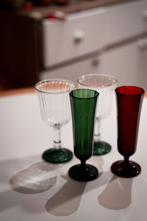 Free Elegant collection of colored glass goblets on a kitchen counter, perfect for holiday decor. Stock Photo