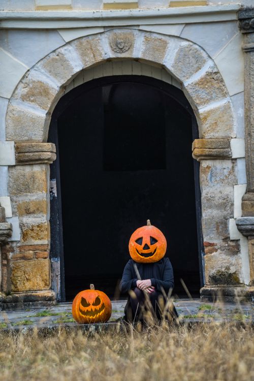 Free An eerie Halloween scene featuring costumed pumpkin heads in front of an ancient arch in Guasca, Colombia. Stock Photo