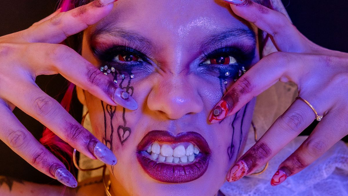 A vivid close-up of a person with artistic, gothic makeup and intricate nail art, expressing a dramatic and surreal style.