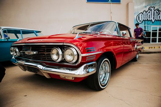 Red vintage Chevrolet parked outdoors. Classic design and shiny chrome details.