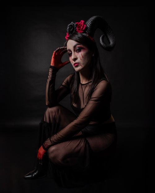 Free Captivating portrait of a woman in surreal makeup with horns, evoking gothic and horror themes. Stock Photo