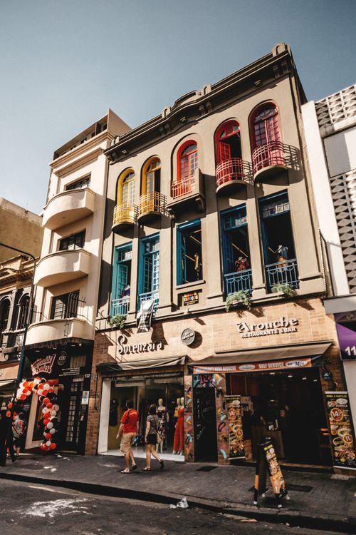 Free Vibrant storefronts with colorful balconies in an urban setting, capturing street life and architecture. Stock Photo