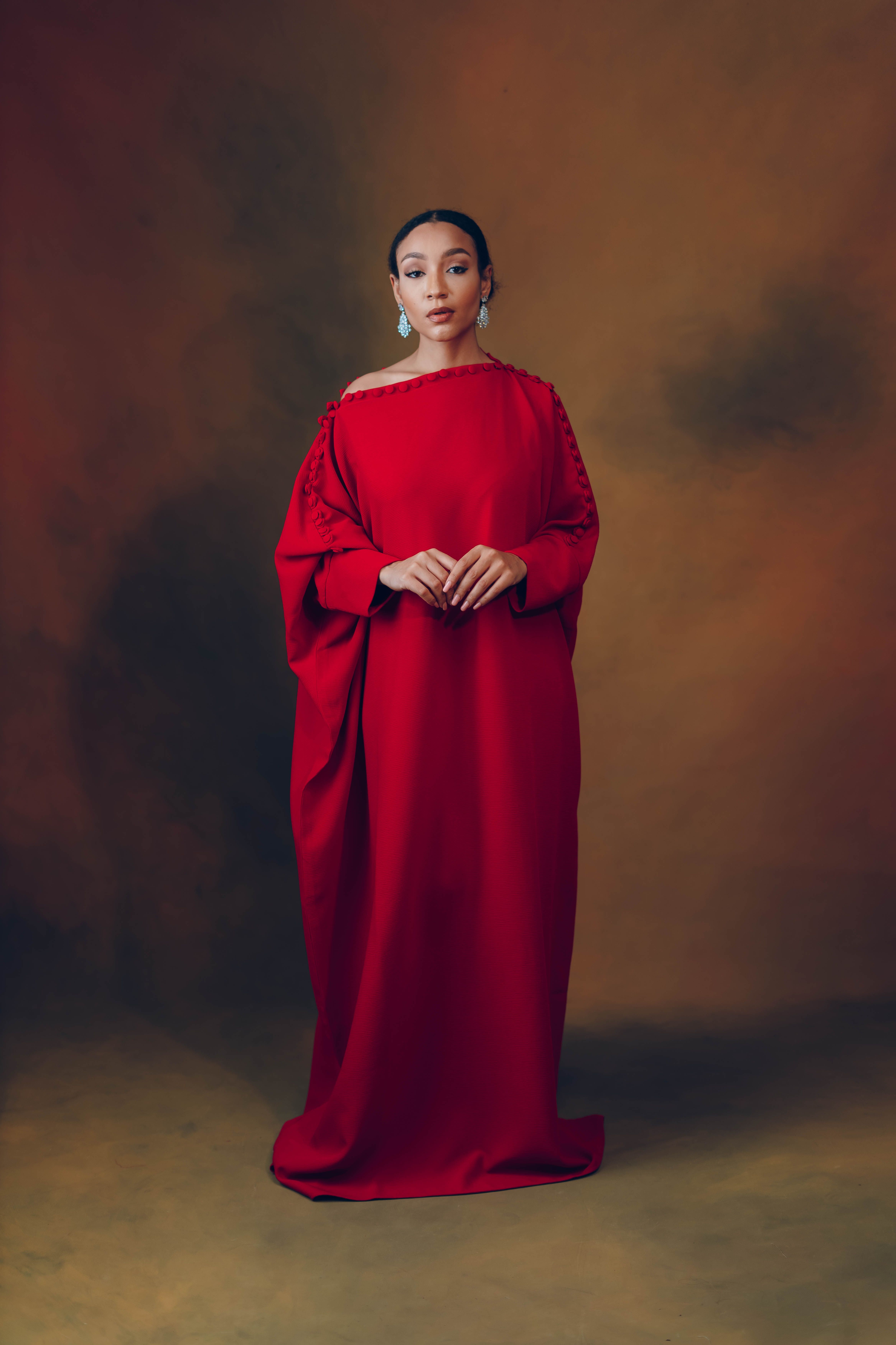 Striking portrait of a woman in a red traditional gown, exuding grace and elegance.
