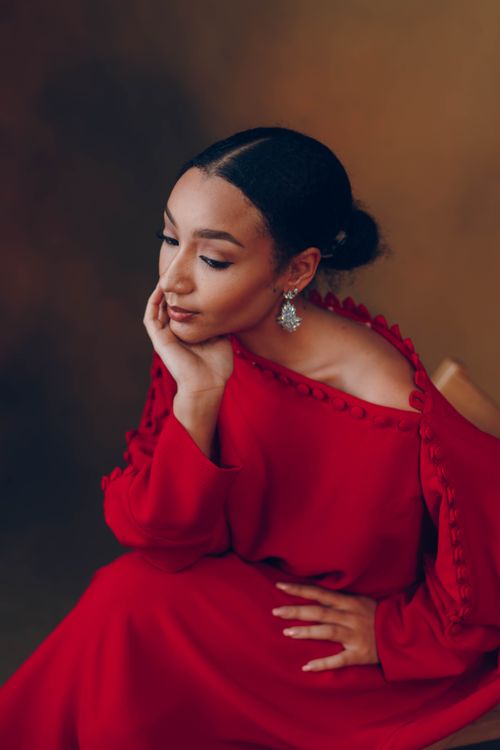 Free A serene portrait of a woman in a stylish red dress, showcasing Nigerian elegance. Stock Photo