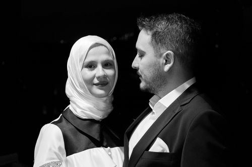 Free Portrait of an elegant couple in black and white formal attire, embracing intimacy and style. Stock Photo
