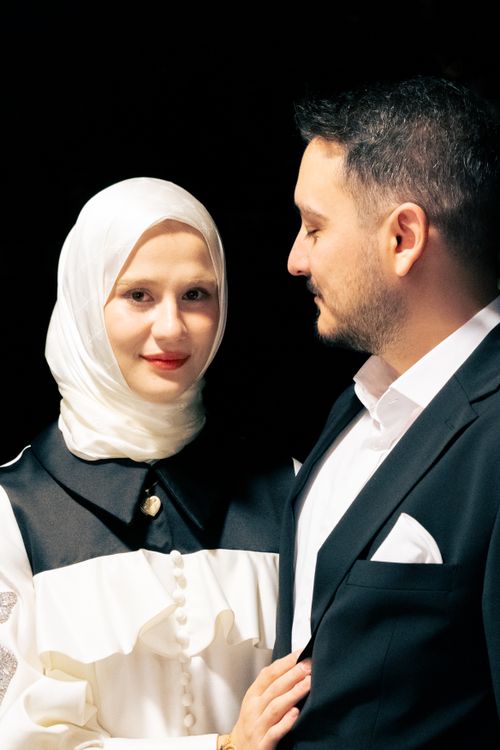 Free A sophisticated couple poses together in elegant formal attire. Stock Photo