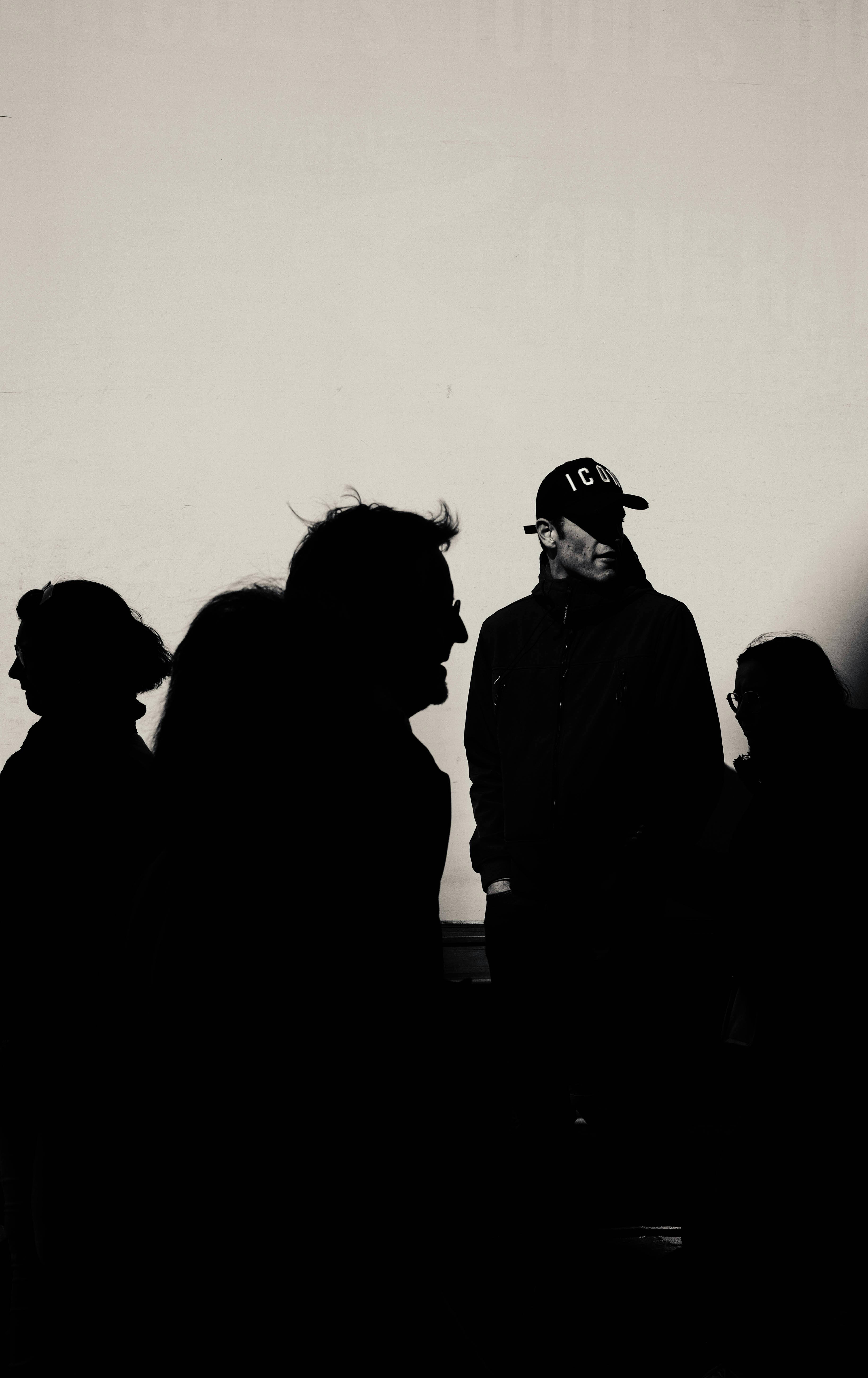 Безкоштовне Силуети людей на світлому фоні створюють драматичний ефект. стокове фото