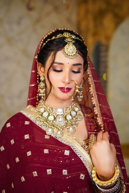 Free A beautiful Indian bride adorned with traditional jewelry and red sari. Stock Photo