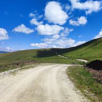 Gravel road through green hills by Esma Yalçın on Pexels