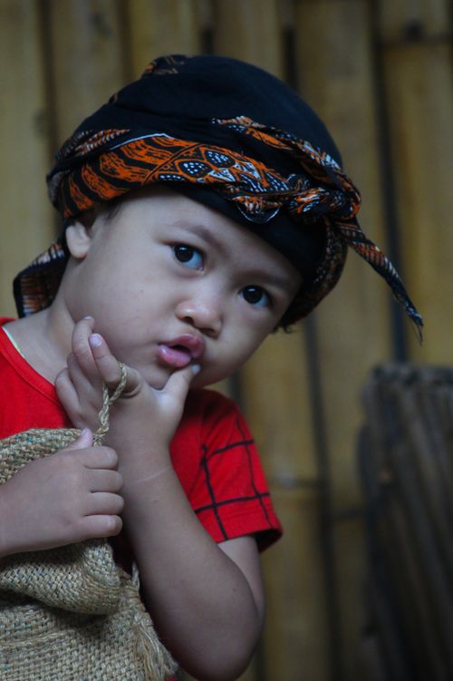Free Young child wearing a traditional headwrap, posing indoors. Stock Photo
