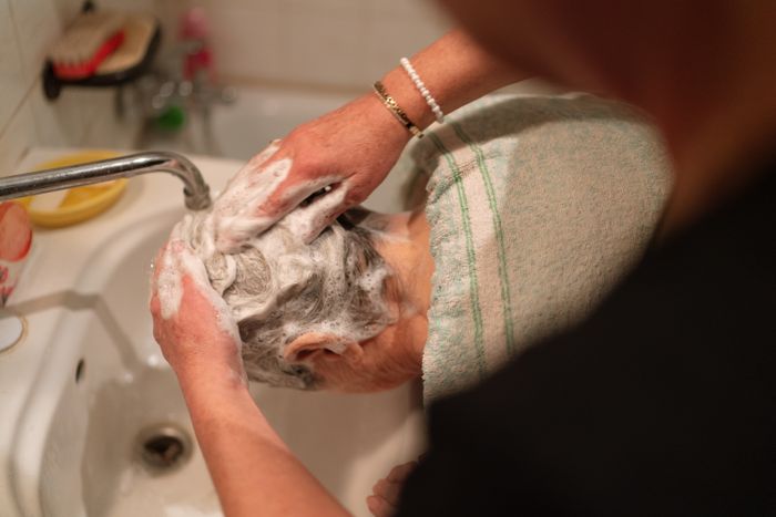 Cuidadora lavando el pelo a una persona mayor