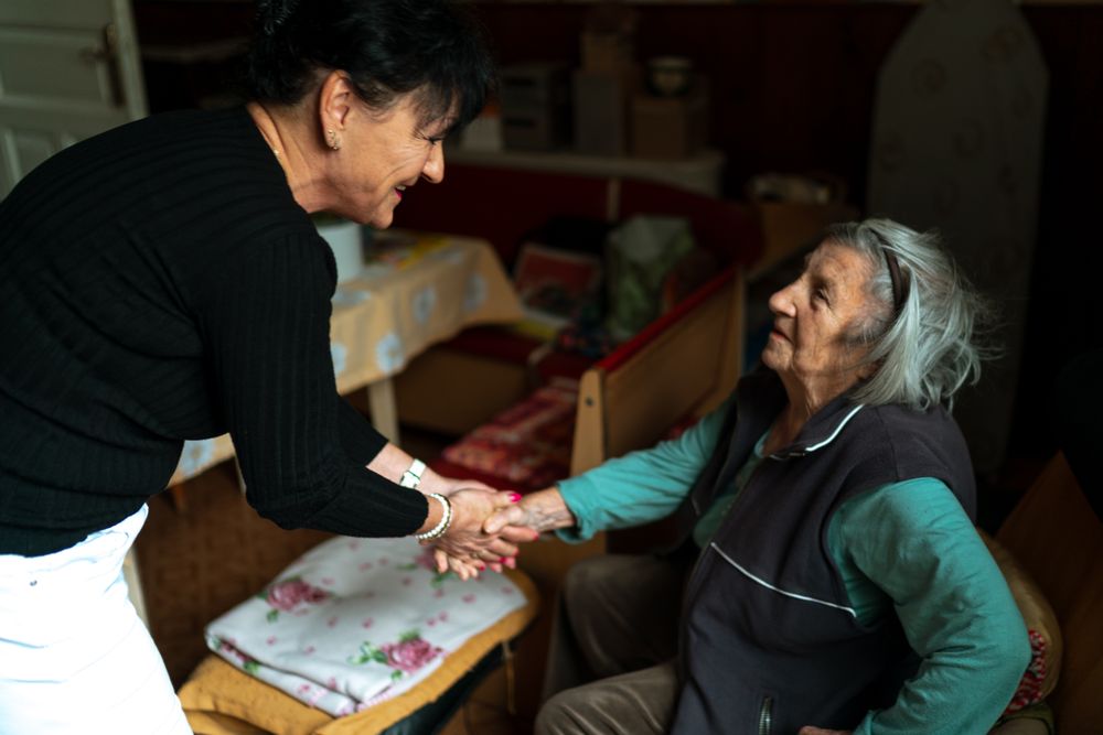 A DMV Accessibility specialist greeting a senior client warmly at the start of a home visit