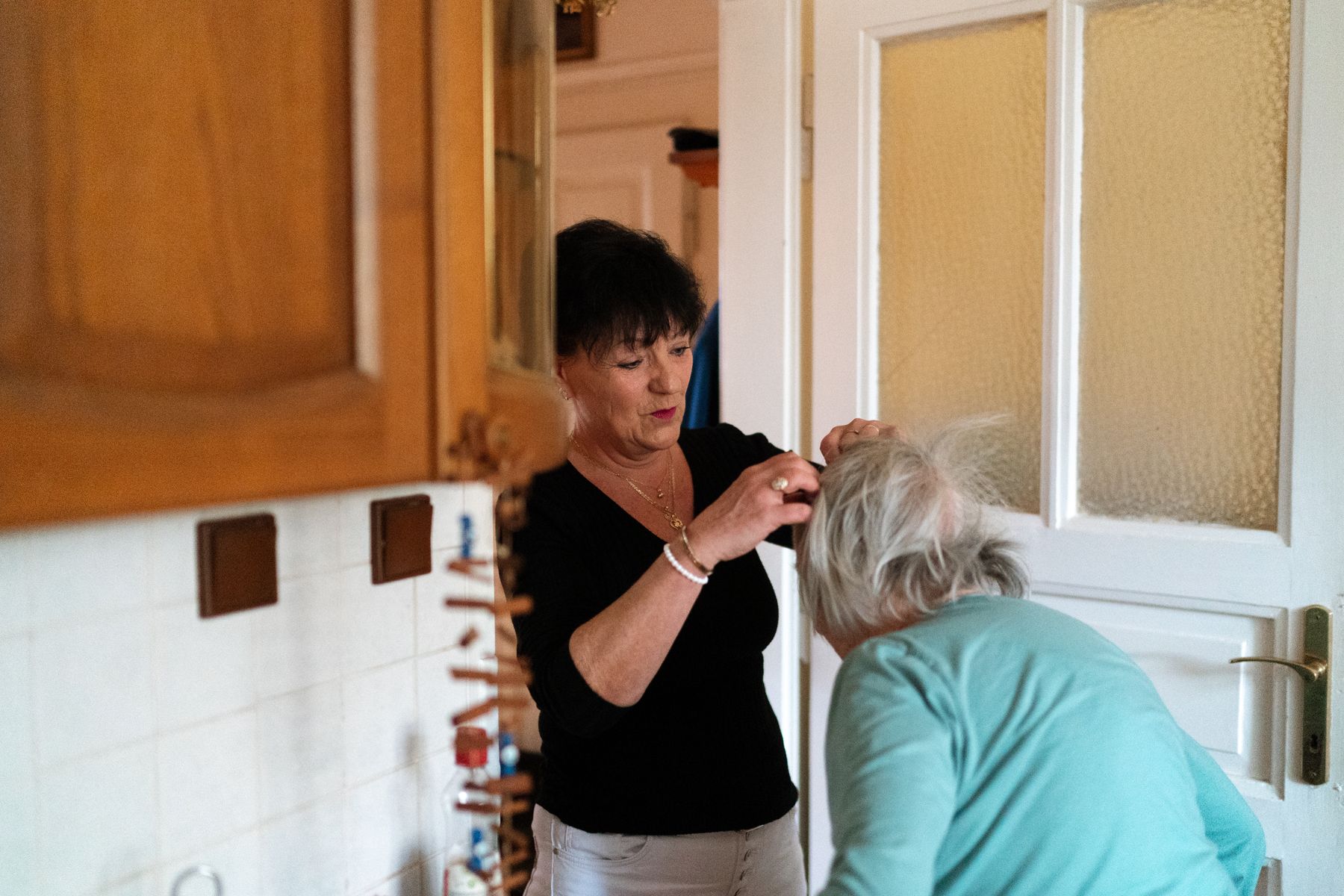 Caregiver assisting an elderly woman in a calm home setting