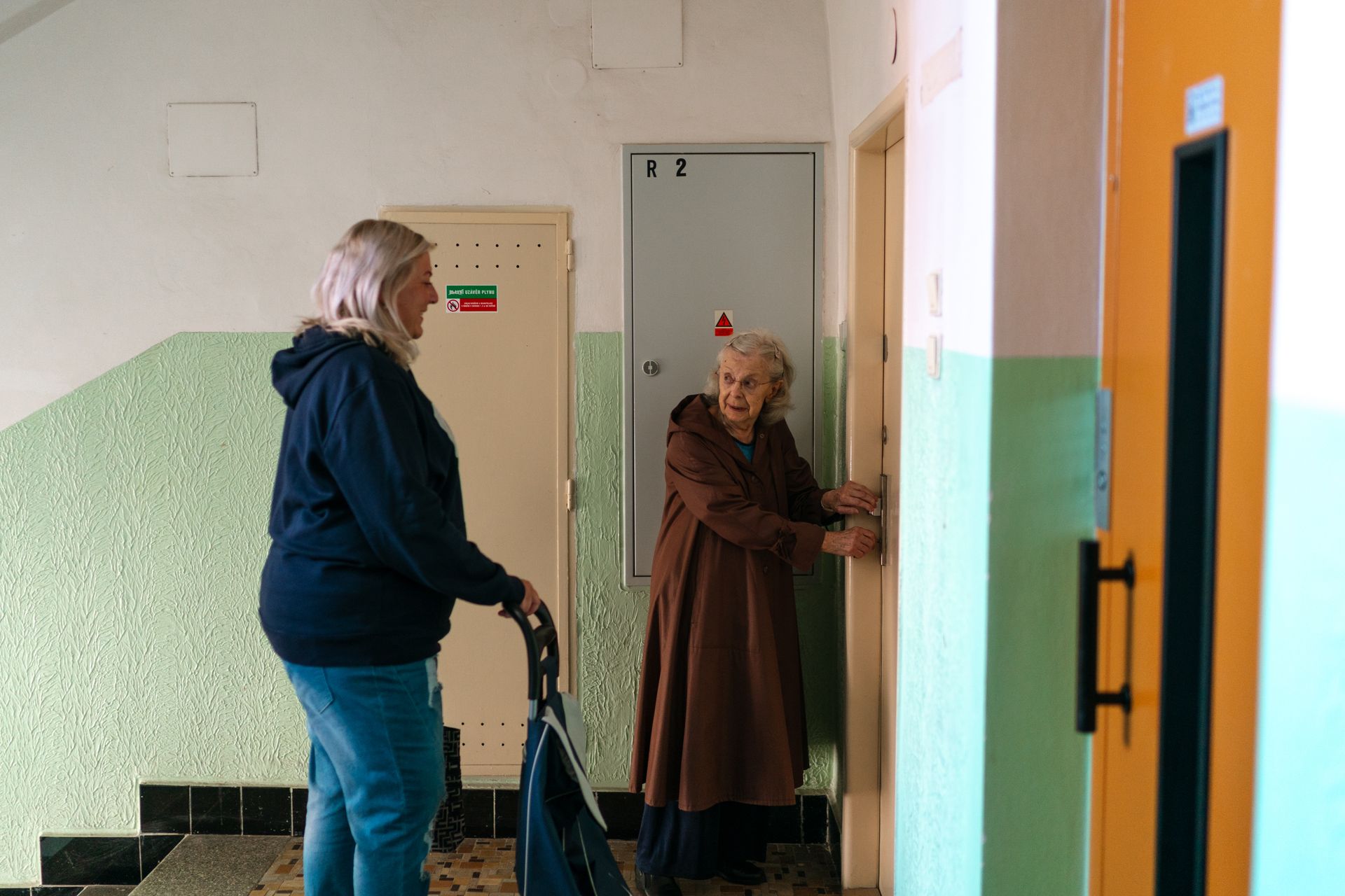 A caregiver greeting a senior woman at her front door