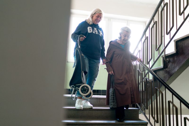Caregiver helping an older woman safely at home