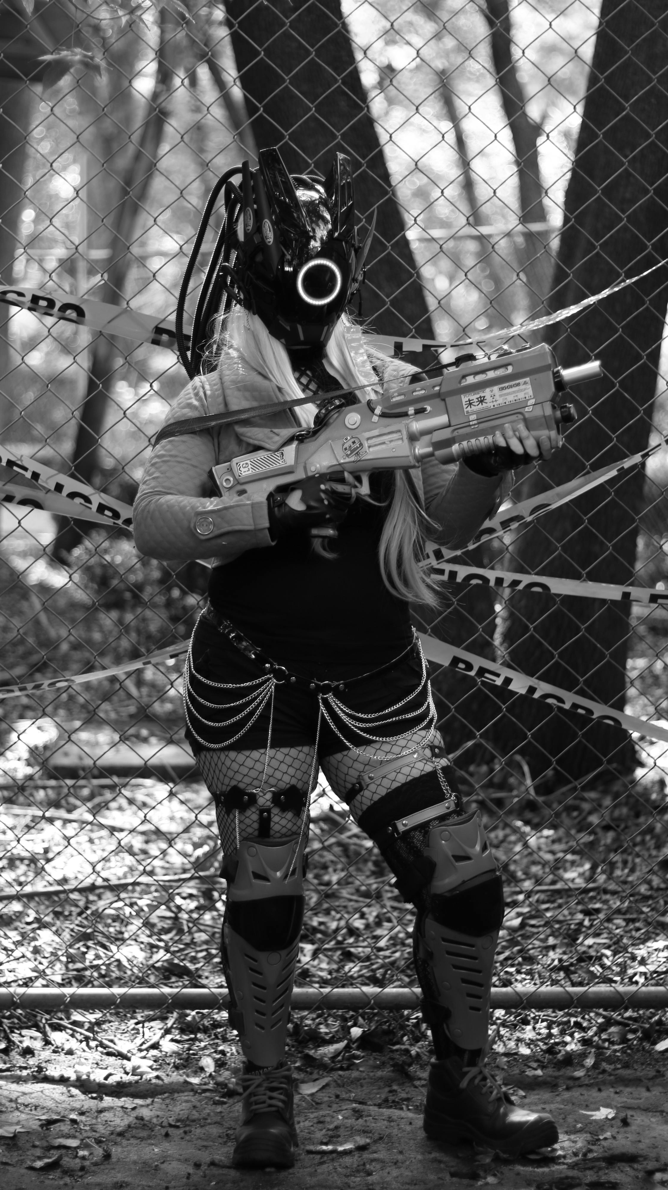 Cyberpunk character in a futuristic ensemble holding a toy gun in a forest setting, conveys sci-fi adventure.