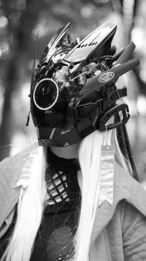 Free Black and white image of a person wearing a futuristic sci-fi helmet in an outdoor setting. Stock Photo