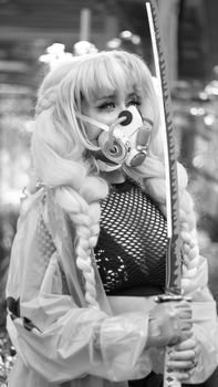 Black and white image of a fashionable woman wearing a mask and holding a sword, exuding a futuristic and dramatic vibe. — photo by Anya  Juárez Tenorio