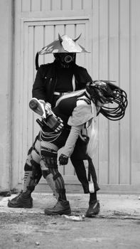 Black and white photo of two cyborg samurai in a futuristic combat scene, outdoors.