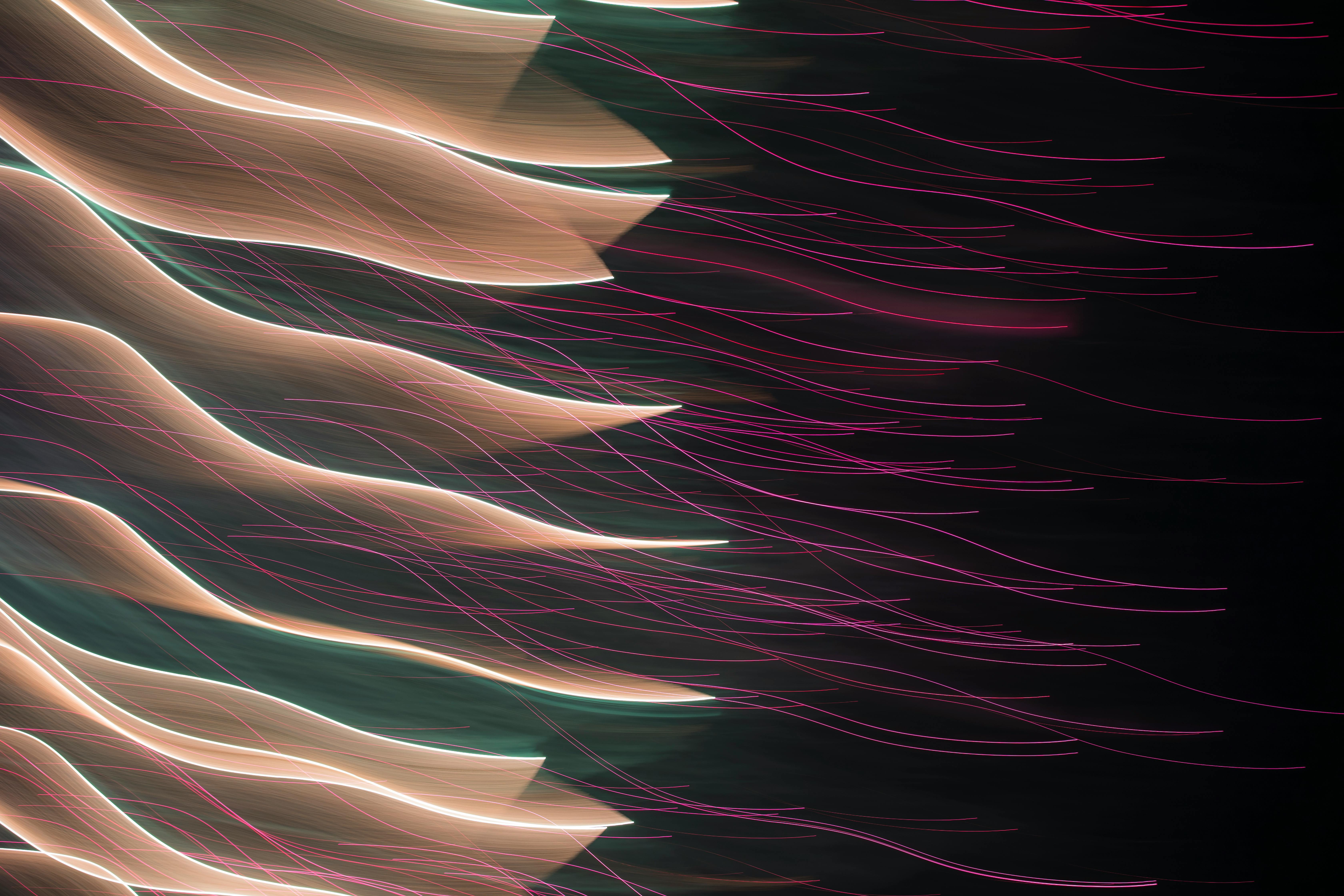 Colorful abstract light trails creating a dynamic visual effect against a dark backdrop.