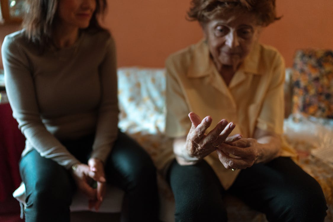 An elderly person receiving care at home, showcasing a warm generational connection between caregiver and senior.