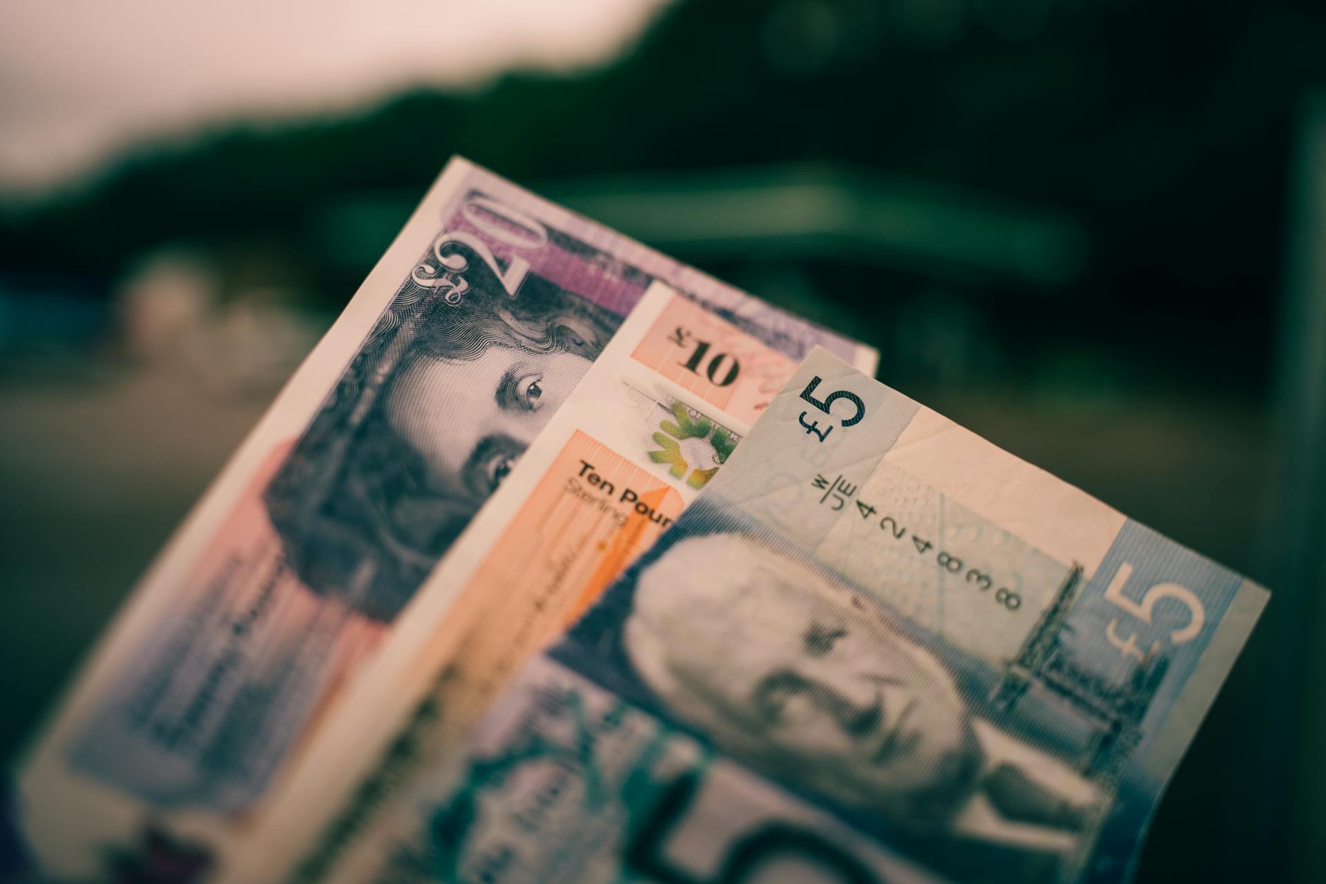 British five and ten pound notes close-up with blurred background.