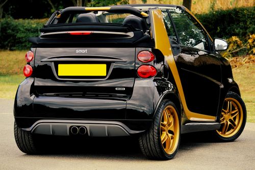 Free Sleek black and gold convertible car focused on modern design and style, parked outdoors. Stock Photo
