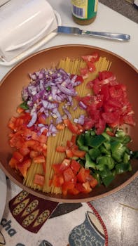 Vibrant display of fresh vegetables and pasta ready for cooking.