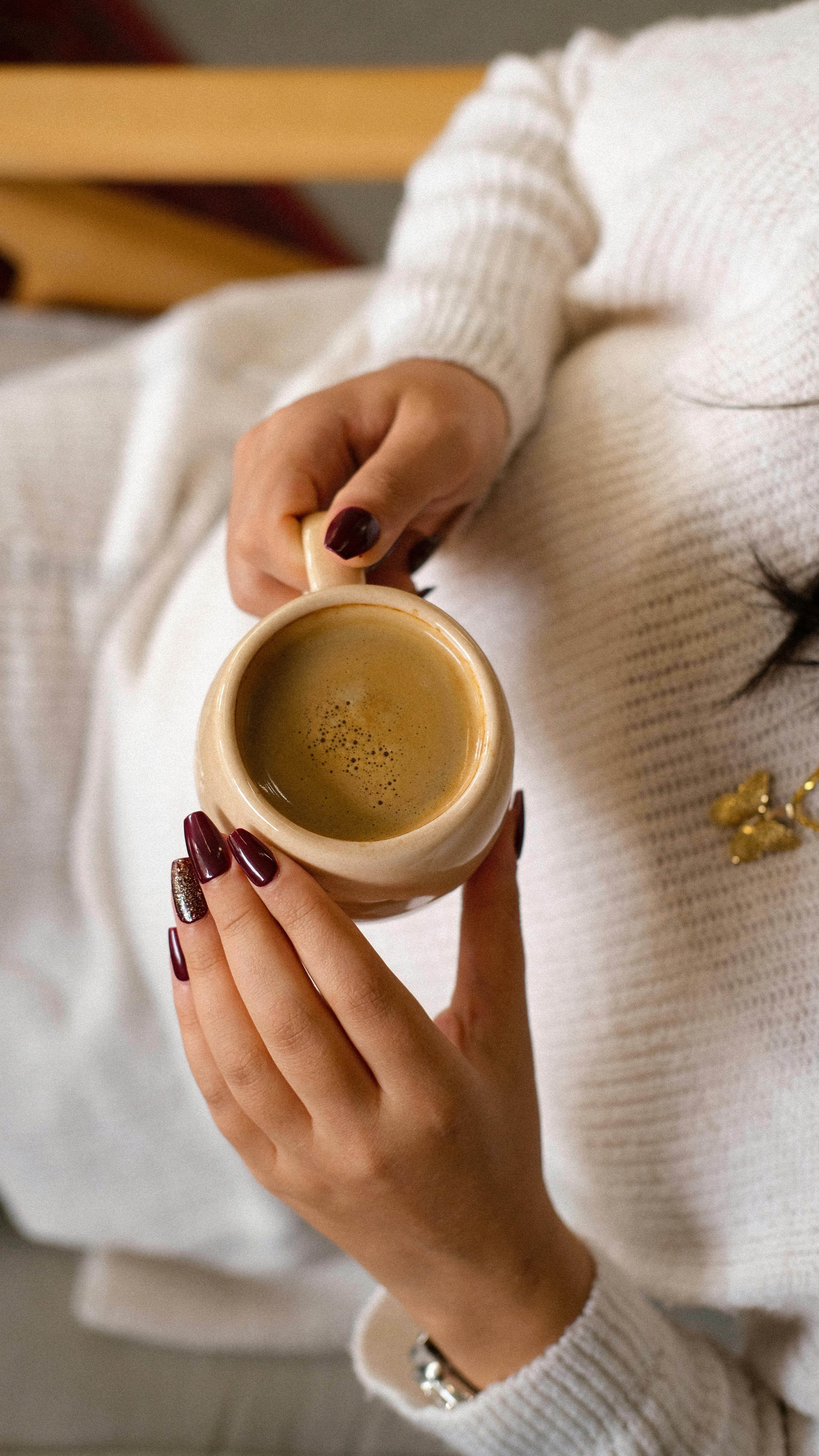 Woman enjoying a cozy coffee break in a warm sweater, perfect for autumn relaxation.