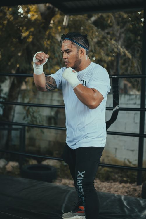 Free A focused boxer practices his punches outdoors, showcasing determination and strength. Stock Photo