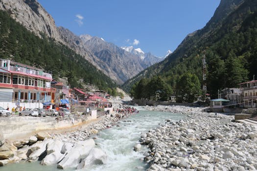 Lively Himalayan village scene with mountains, river, and people enjoying the landscape.