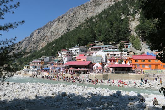Busy village scene with colorful buildings by a mountainous riverside.