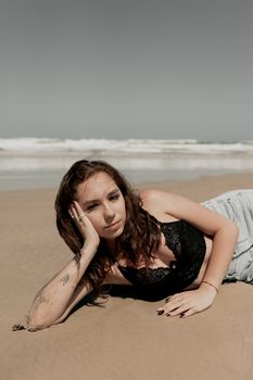 A young woman in casual beachwear relaxes on a sunny shore, exuding summer vibes.