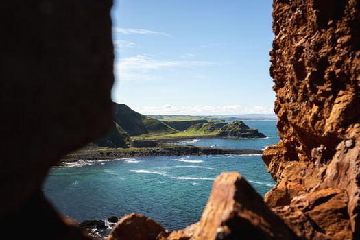 Breathtaking view of Giant's Causeway's rugged coastline and blue sea in Northern Ireland.