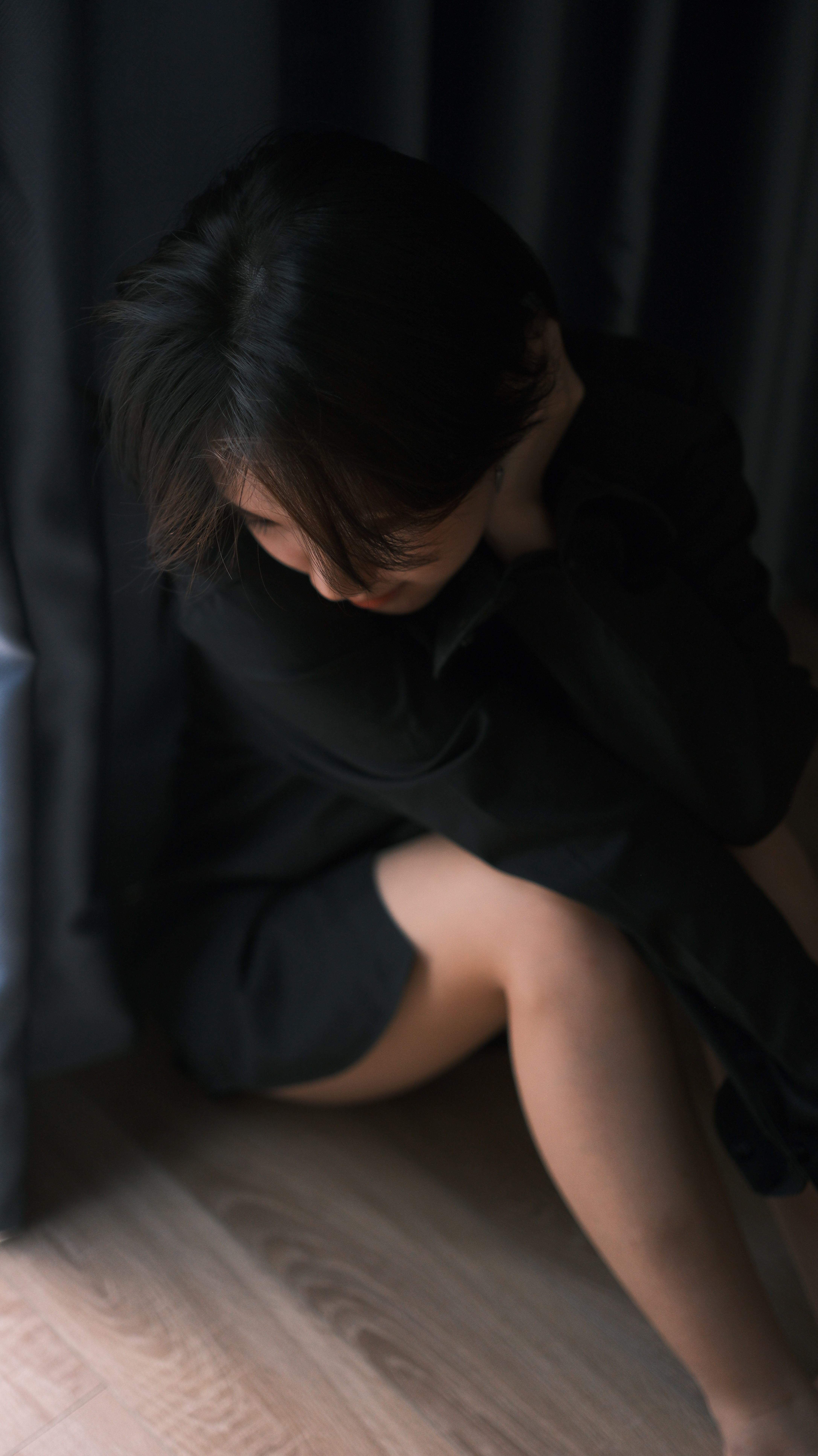 Contemplative Woman Sitting in Dark Room · Free Stock Photo