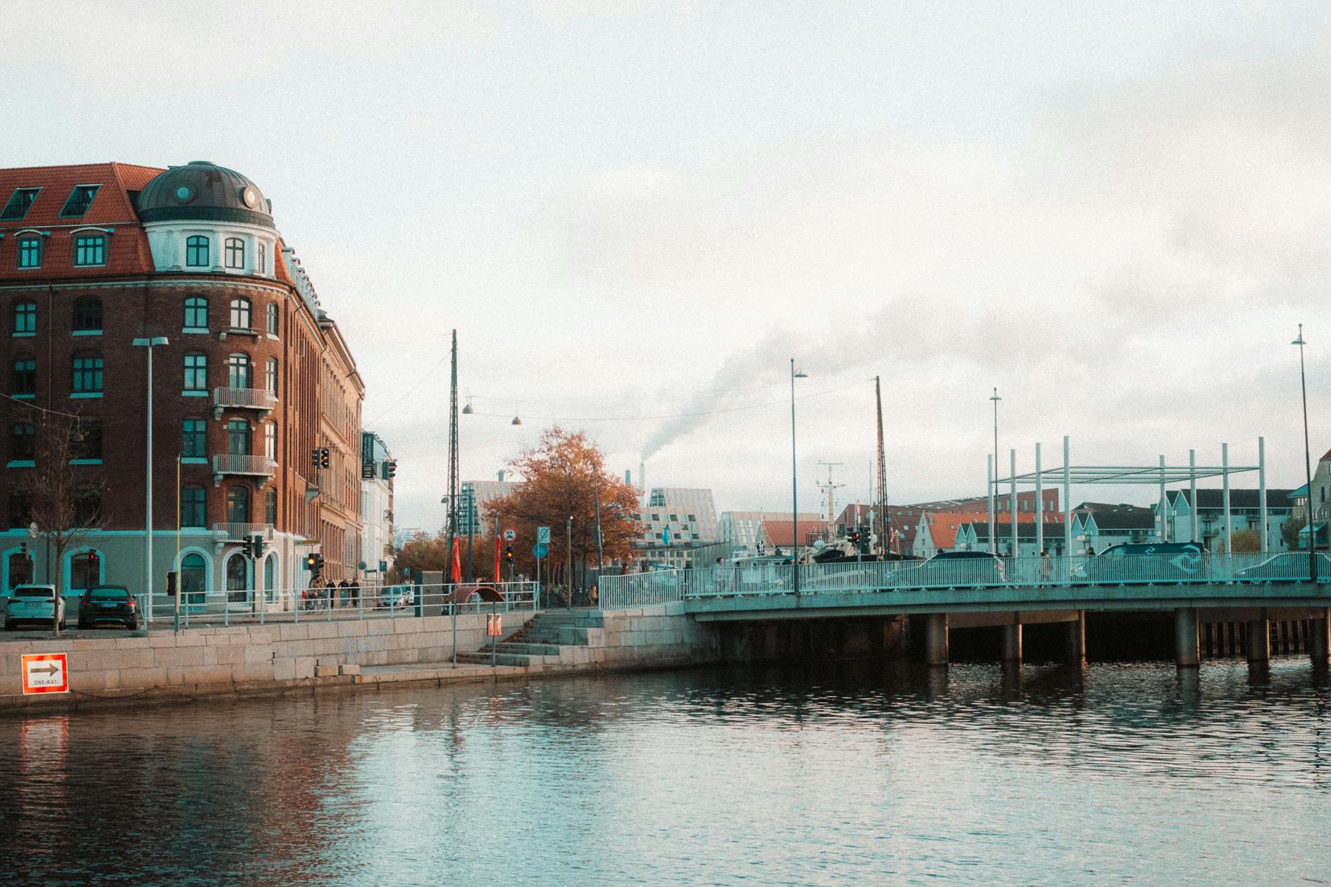 Beautiful urban scene in Copenhagen featuring historic buildings and a bridge over calm water.