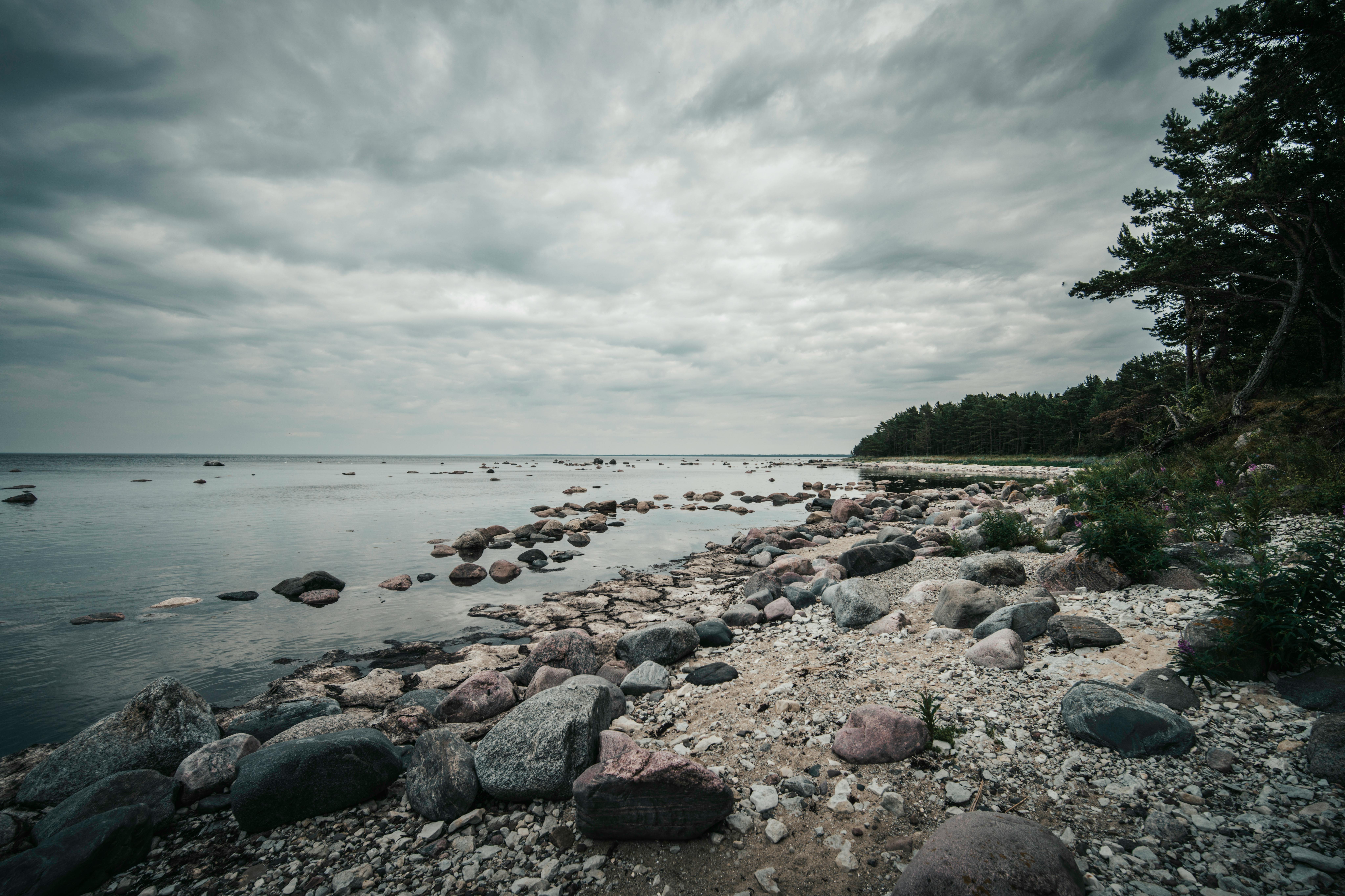 Discover the untouched beauty of Spitham Bay's rocky beach under dramatic clouds in Estonia.