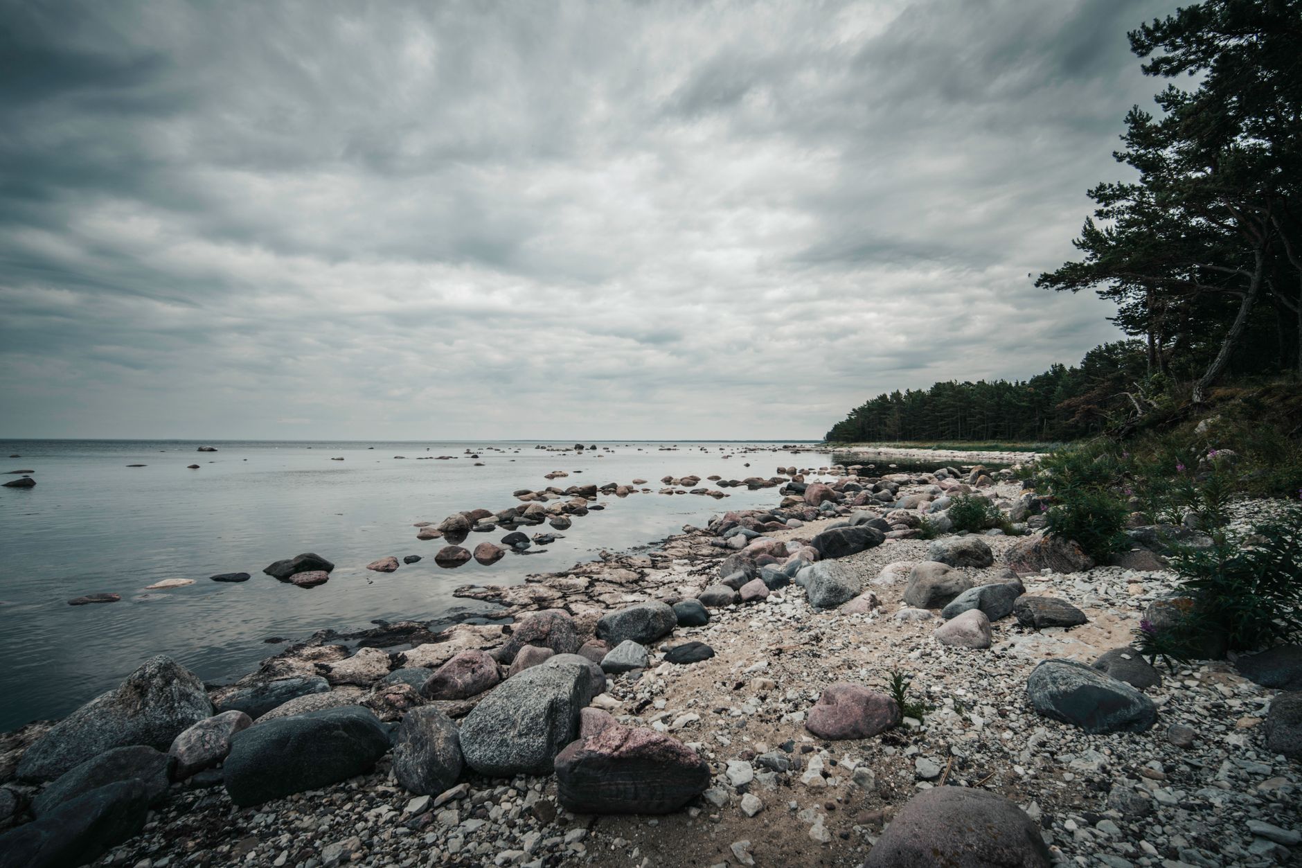 Discover the untouched beauty of Spitham Bay's rocky beach under dramatic clouds in Estonia.