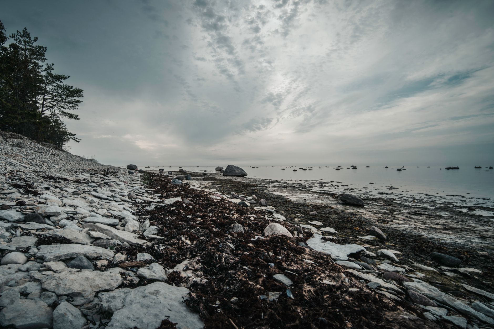 Captivating rocky shore with dramatic clouds at Põõsaspea Neem, untouched nature in Estonia.