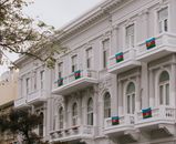 Beautiful historic building in Baku adorned with Azerbaijani flags, showcasing architectural elegance.