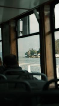 Enjoy a serene view of an island from a ferry, with a person inside adding life to the scene.