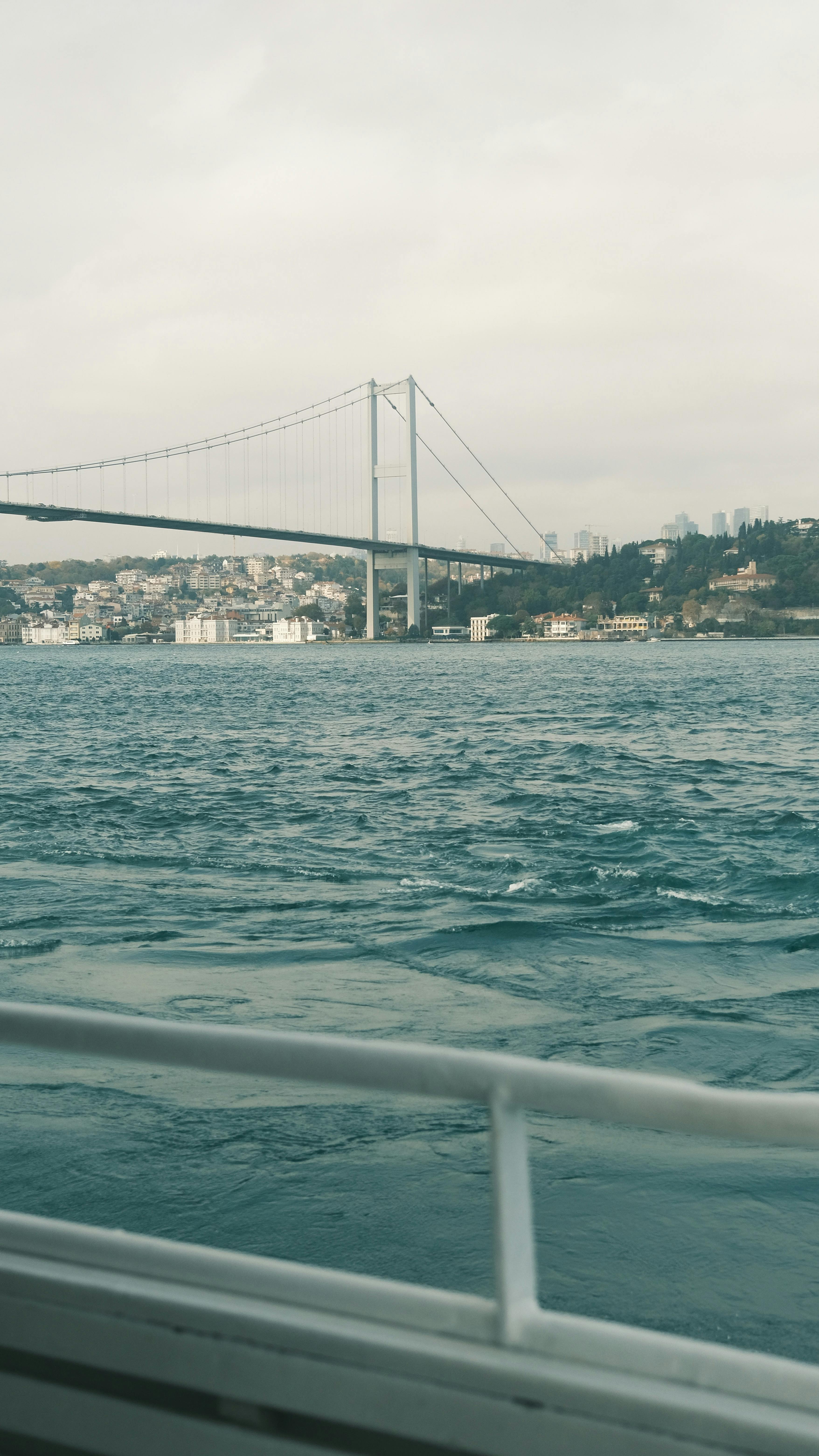 Gratuit Vue panoramique du pont du Bosphore depuis un bateau à Istanbul, une expérience de voyage en mer sereine. Photos