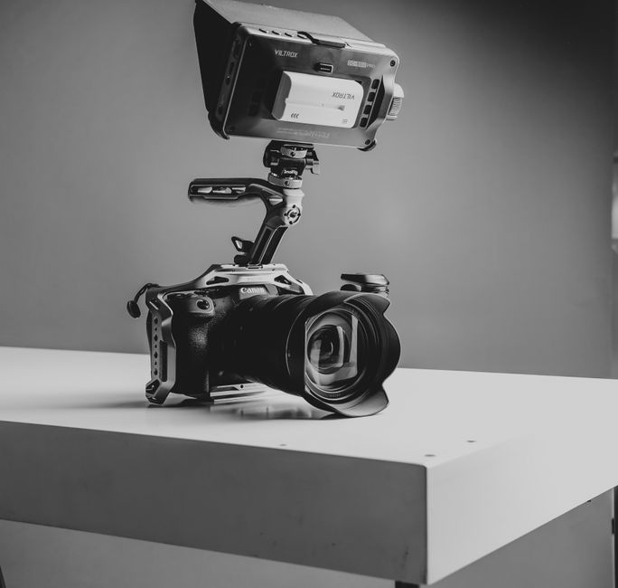 Câmera mirrorless em rig de vídeo gravando 4K com microfone externo e monitor HDMI
