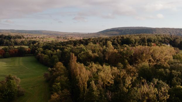Drone shot of dense forest and rolling hills in Grand Est, France, showcasing natural beauty.