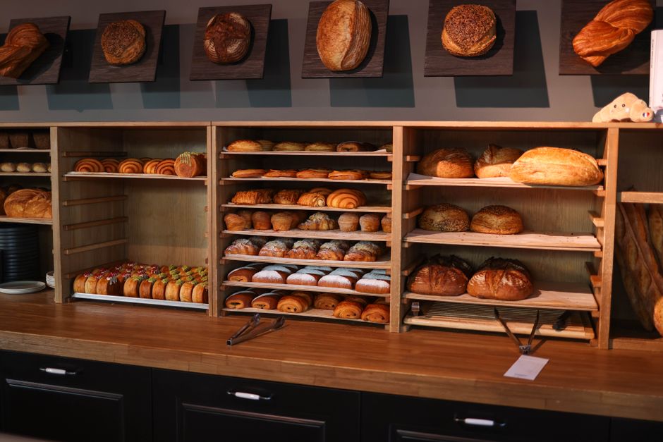 A variety of freshly baked artisan breads and pastries displayed in a bakery.