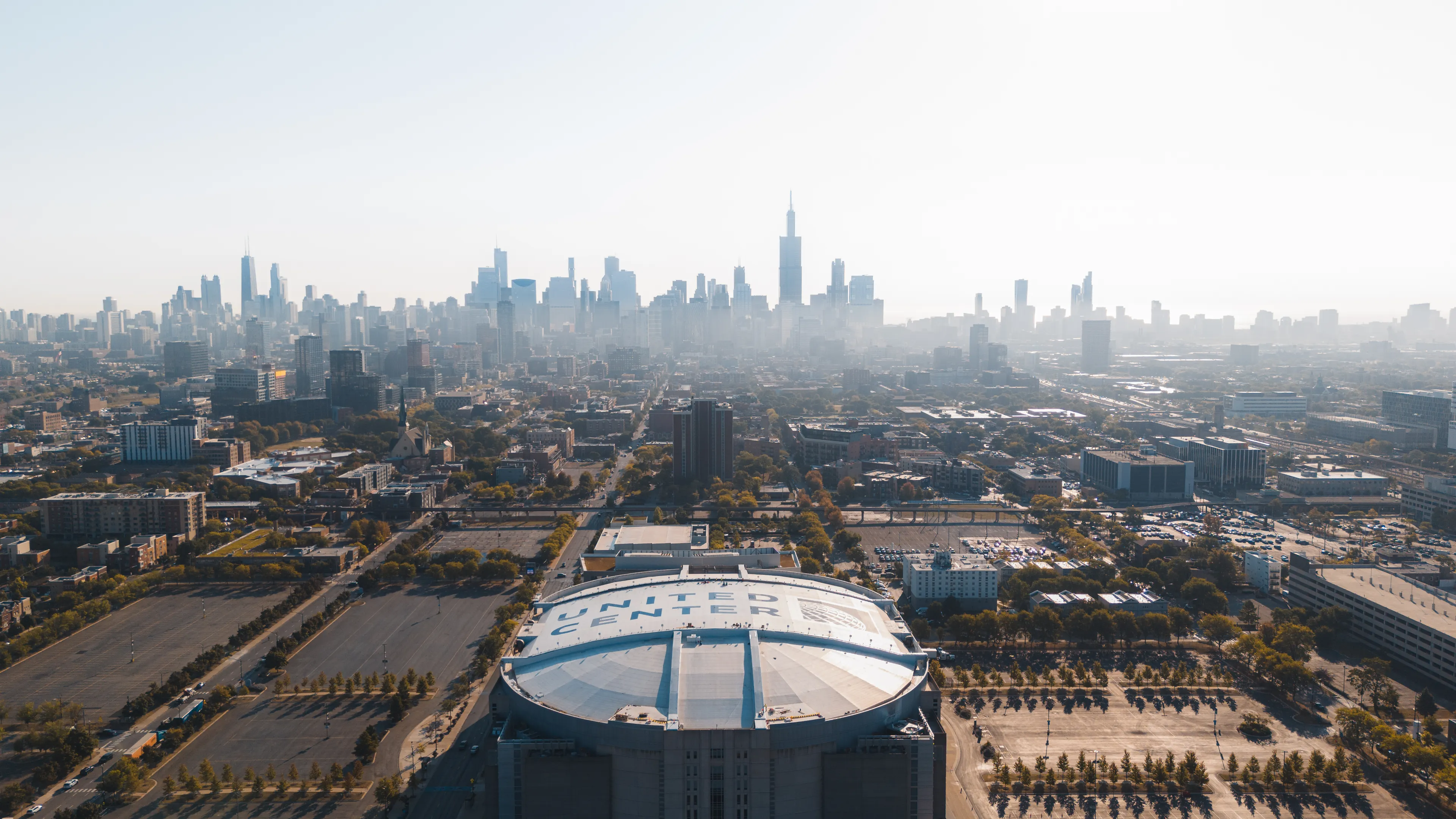 A stunning aerial view of the United Center and Chicago skyline on a bright day.