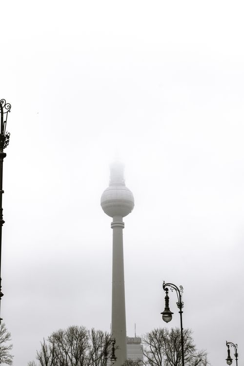 Free A foggy day in Berlin showcasing the iconic TV Tower amidst barren winter trees. Stock Photo