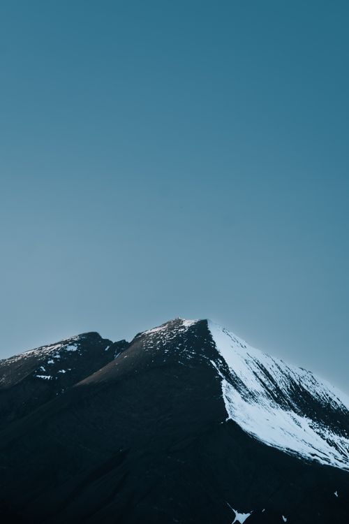 Free A stunning snow-capped mountain peak under a clear blue sky, capturing nature's majesty. Stock Photo